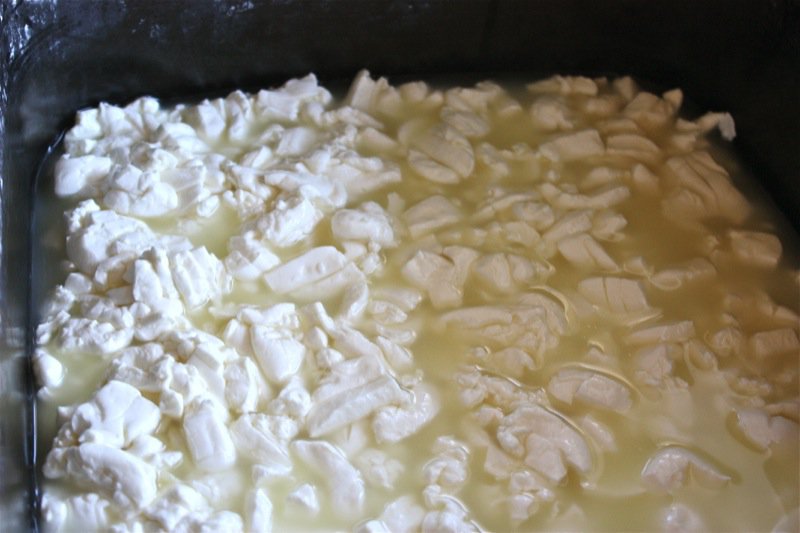 Heated curd after stirring and whey strained off